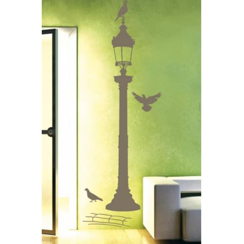 Offez une touche de lumière avec notre sticker Réverbère Bronze ! mis en ambiance, 2ème proposition autocollant mural réverbère bronze avec pigeons collé sur un mur vert et jaune