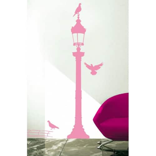 Offez une touche de lumière avec notre sticker Silhouettes de réverbères roses ! mis en ambiance, 1ère proposition sticker mural réverbère rose avec pigeons mis en ambiance sur un mur blanc