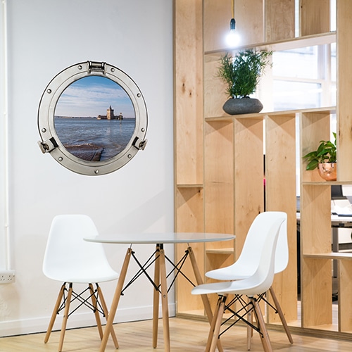 Adhésif déco mural fenêtre ronde avec vue sur le fort Louvois mis en ambiance dans une salle à manger avec claustra en bois