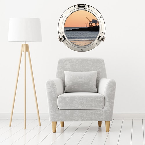 Intérieur scandinave personnalisé avec un hublot de bateau adhésif en trompe-l'oeil représentant une vue sur le port un soir de pêche.