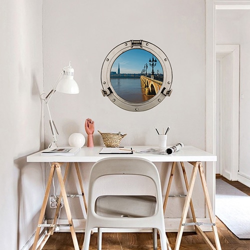 Bureau personnalisé avec un Autocollant mural de fausse fenêtre ronde en trompe-l'oeil avec une vue sur le pont de pierres comme un hublot de bateau.