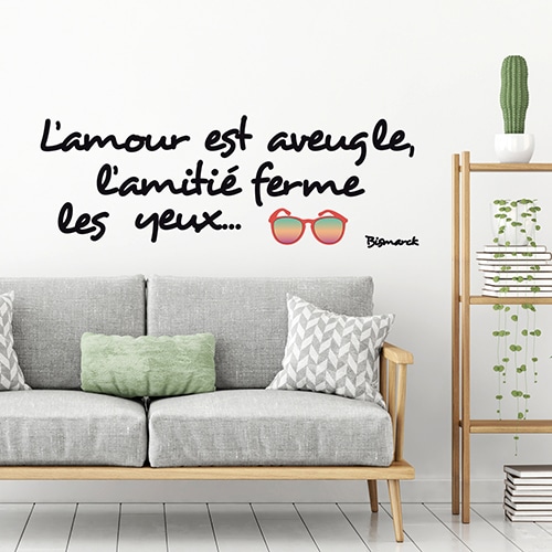 Stickers planche Amour et Amitié au-dessus d'un canapé gris