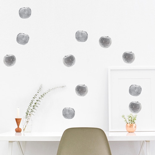 Pommes en Argent en sticker collé sur un mur blanc au-dessus d'un bureau
