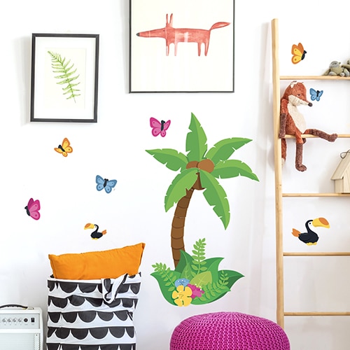 Autocollant dessiné avec papillons et cocotier sur les murs d'une chambre d'enfant