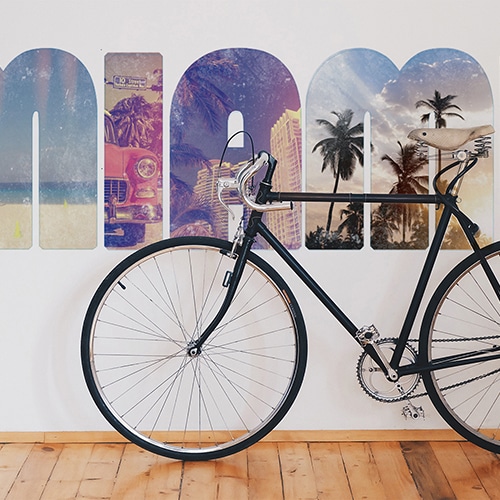 Sticker décoratif mural papillons en 3D modèle à triangles noirs et gris collés dans une pièce avec un vélo