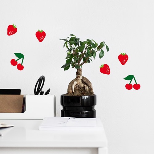 Stickers muraux adhésifs fraises et cerises sur un mur blanc