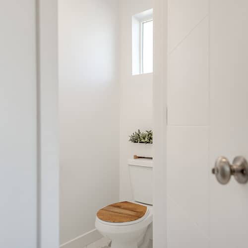 Toilettes blanches avec un sticker déco citation si c'est propre collé au mur