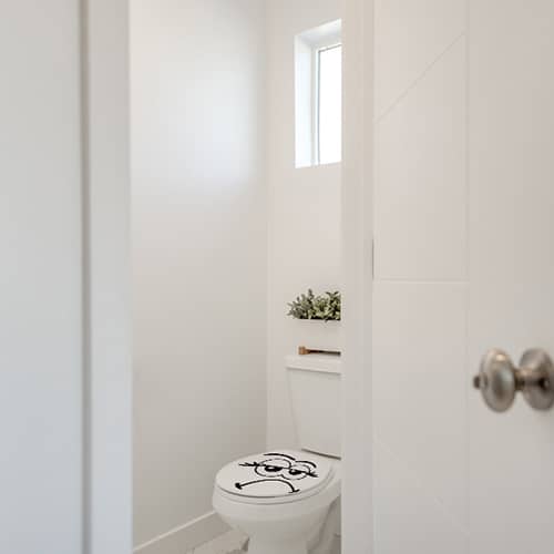 WC classique blanc avec un sticker décoratif Merci de laisser propre