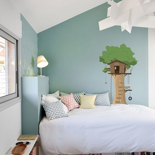 sticker mural pour enfant cabane en haut d'un arbre mis en ambiance sur un mur couleur claire