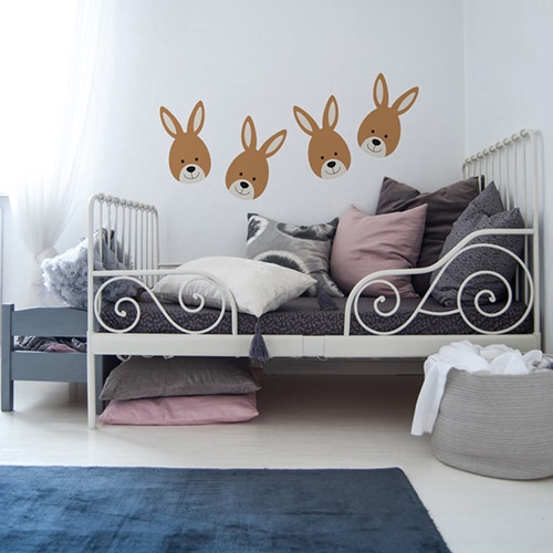 quatre adhésifs muraux petits lapins pour enfants mis en ambiance sur un mur blanc