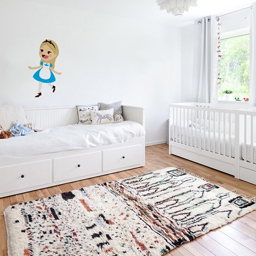 autocollant mural Alice pour enfants mis en ambiance dans une chambre de bébé aux murs blancs