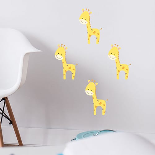 Quatre stickers Girafon pour enfant mis en ambiance sur un mur blanc