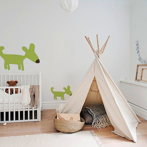 Stickers muraux dessin chien vert pour enfants mis en ambiance sur un mur clair