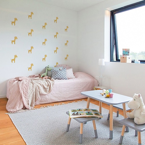 Mosaïque de stickers girafe pour enfants sur mur blanc au dessus du lit
