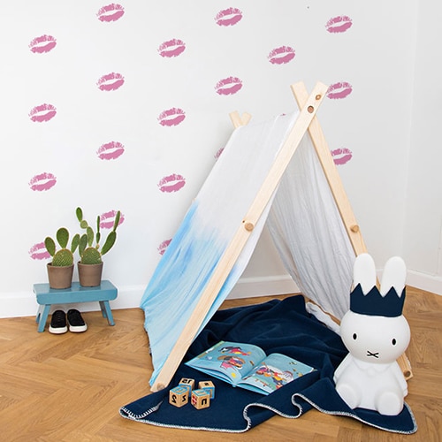 Stickers baisers roses sur mur blanc derrière une mini tente pour enfants