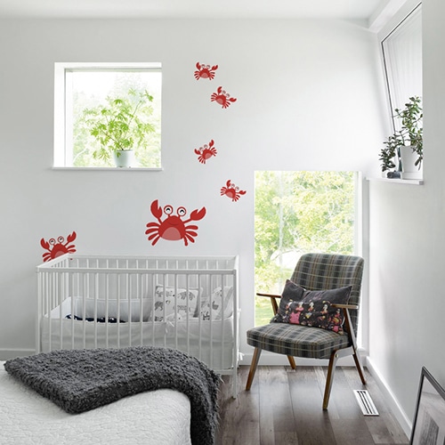 Stickers Crabes rouges enfants disposés sur un mur blanc d'une chambre pour bébé derrière le berceau