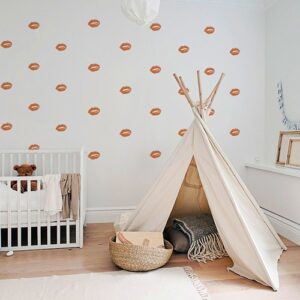 Stickers lèvres oranges mis en mosaïque sur un mur clair d'une chambre d'enfants