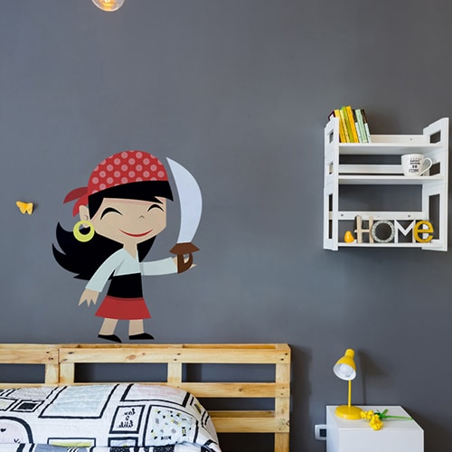 Sticker petite fille pirate souriante avec une épée mis en ambiance sur mur gris foncé