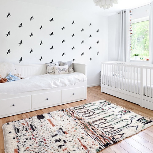 Mosaïque de stickers fées noires sur mur blanc dans une chambre de bébé