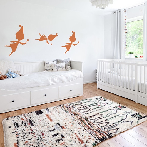trois stickers muraux fées oranges mis en ambiance sur un mur blanc d'une chambre de bébé
