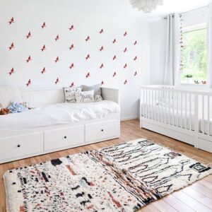 Mosaïque de stickers fées rouges sur mur blanc dans une chambre de bébé