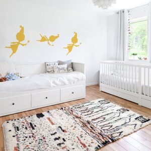 trois stickers muraux fées jaunes mis en ambiance sur un mur blanc d'une chambre de bébé