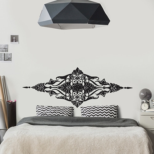 Sticker adhésif Papillons noir et blanc posé sur un mur de salon au dessous d'une horloge
