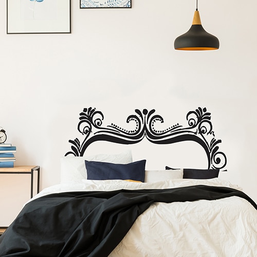 Sticker adhésif Papillons noir et blanc posé sur un mur de salon au dessous d'une horloge