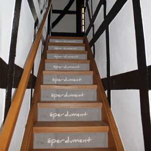 Escalier avec autocollants "éperdument" dans ancienne maison à colombages