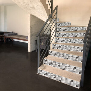 Stickers escaliers avec pour motif triangles emboités noir gris et blanc sur marches en pierre