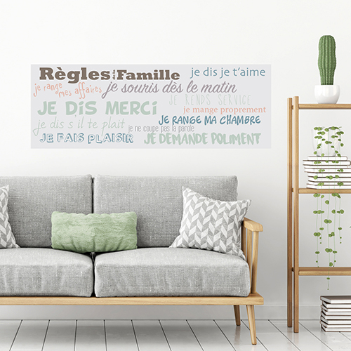 Mur d'un sallon orné d'un sticker adhésif mural donnant les règles de la famille.