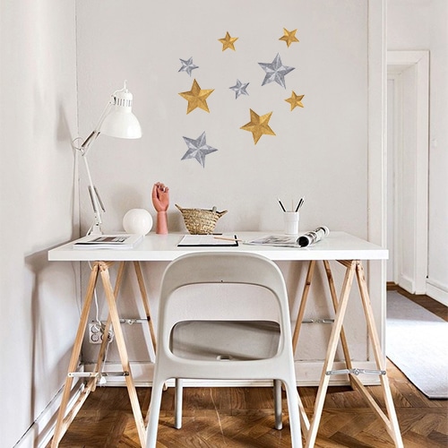 Sticker étoiles or et argent collé au mur d'un petit bureau