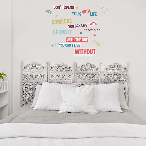 Citation Don't Spend collée au dessus d'un lit au mur d'une chambre