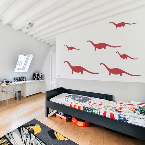 5 stickers dino rouges posés au mur d'une chambre pour enfants