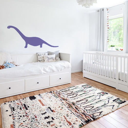 sticker dino violet géant collé au mur d'une chambre d'enfant