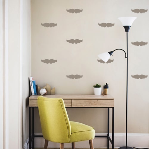 Frise de stickers moustache taupe collée au mur d'un petit bureau