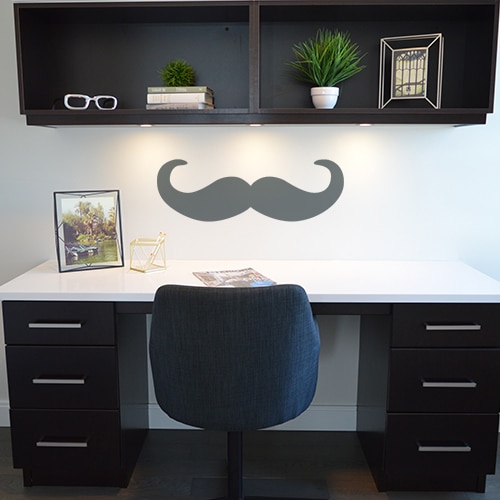 Moustache en croc grise foncée géante posée sur le mur d'un bureau