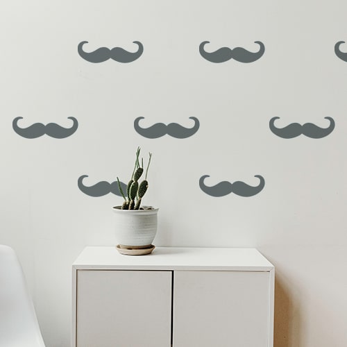 sticker adhésif moustache en croc grise foncée Ensemble de petites moustaches en croc couleur grise foncée stické sur un mur blanc