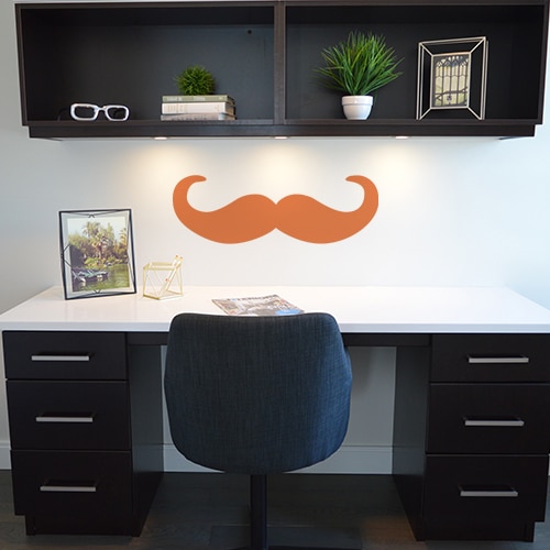 Bureau avec un sticker moustache en croc orange au mur