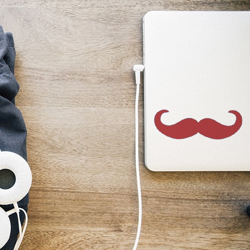 Sticker autocollant moustache en croc rouge collée sur un ordinateur