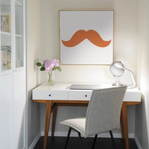 sticker moustache épaisse orange collé sur un tableau mural