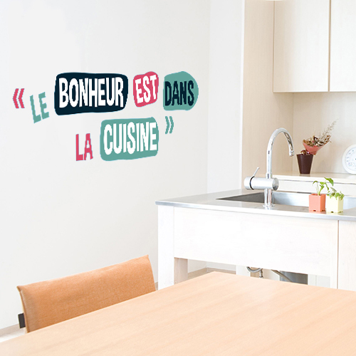 sticker mural coloré citation en espagnol collé au mur d'un salon moderne avec des plantes