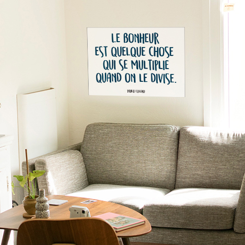 Citation Mauvaise Herbe adhésive collée au mur d'une pièce à vivre.