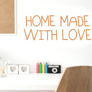 Sticker adhésif citation orange pour décoration murale "home made with love" au dessus d'un bureau blanc