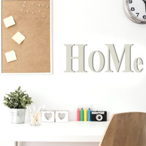 Autocollant texte mural "home" gris citation déco au dessus d'un bureau blanc
