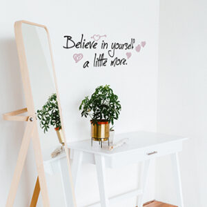 Sticker citation manuscrite Believe in yourself colorée collé au mur blanc d'un dressing