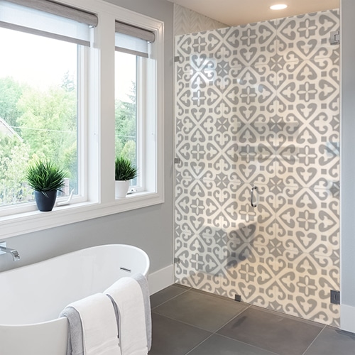 sticker décoratif adhésif motif damier gris et blanc collé à la vitre d'une petite salle de douche avec toilettes