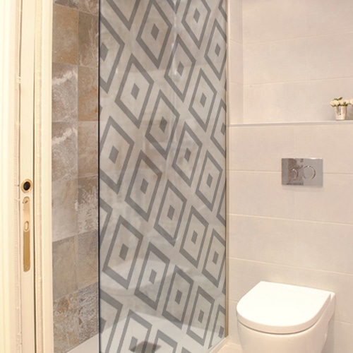 sticker décoratif autocollant motifs losanges d'inspiration méditérranéenne collé sur la vitre d'une douche dans une petite salle de bain