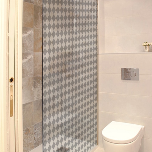 Sticker adhésif décoratif motif petits damiers gris et blanc collé sur la vitre d'une petite salle de bain