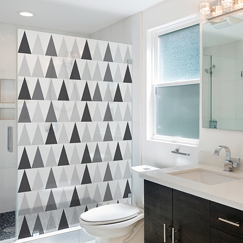 sticker décoratif autocollant motif triangles noirs blanc et gris collé sur la vitre de la douche d'une petite salle de bain